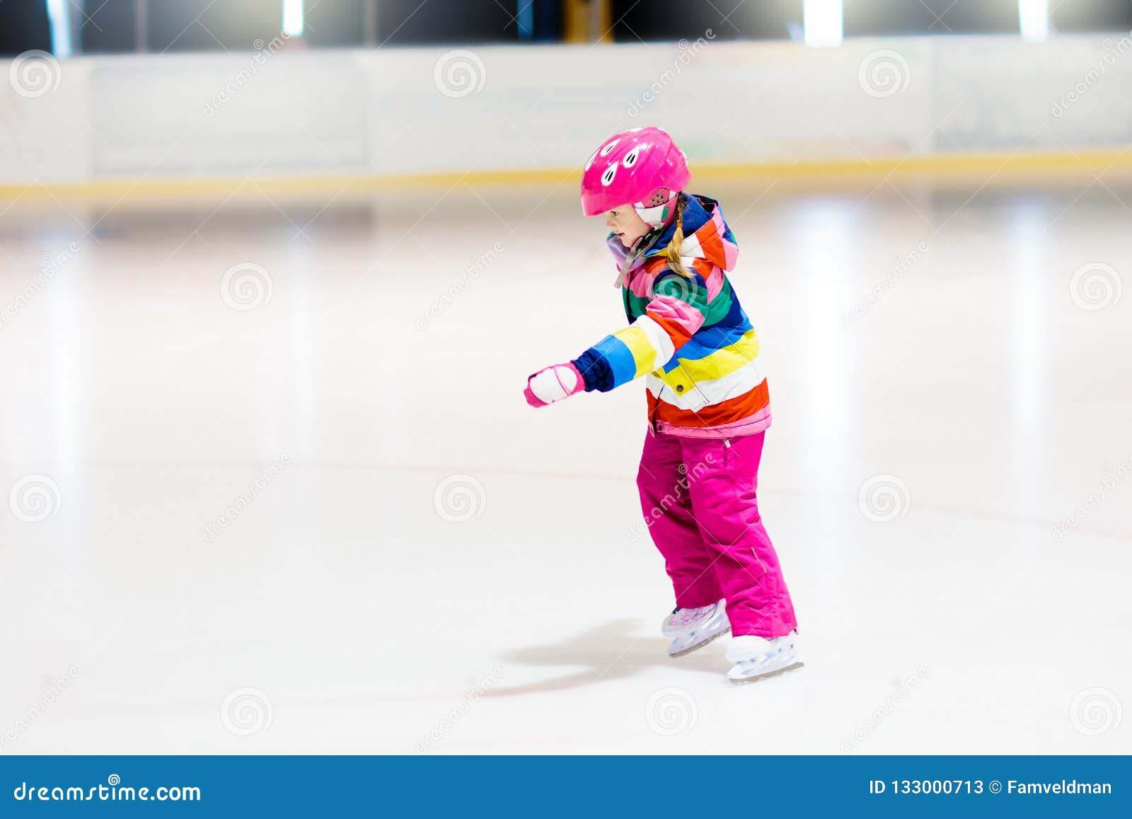 child skating on indoor ice rink. kids skate