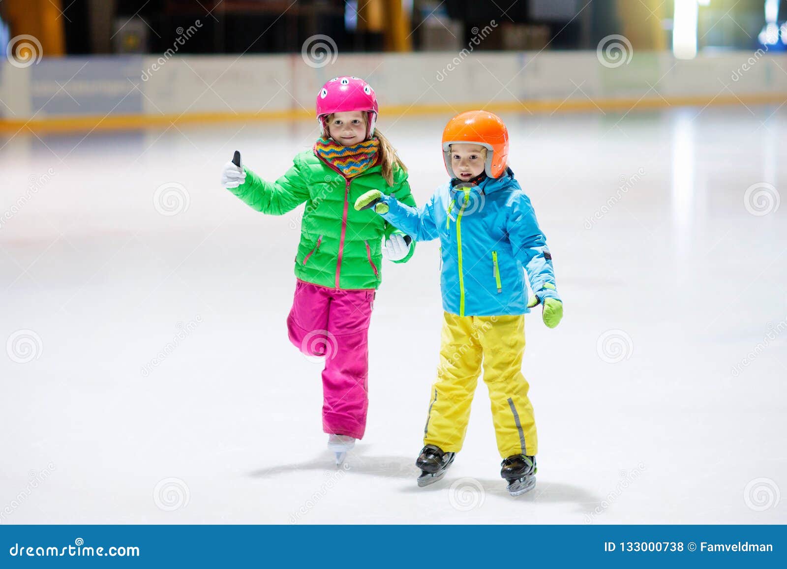 child skating on indoor ice rink. kids skate