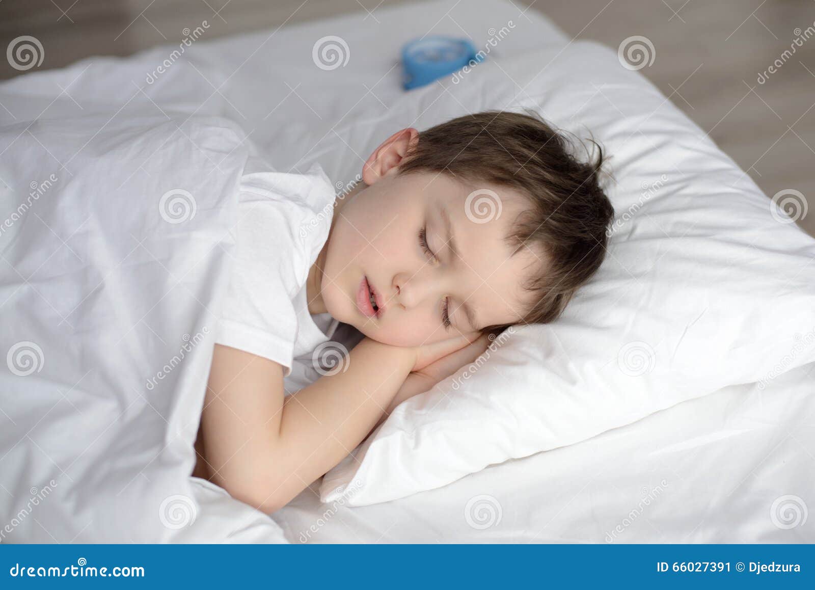 Child sleeping in bed, happy bedtime in white bedroom. Sleeping boy. Sleeping child