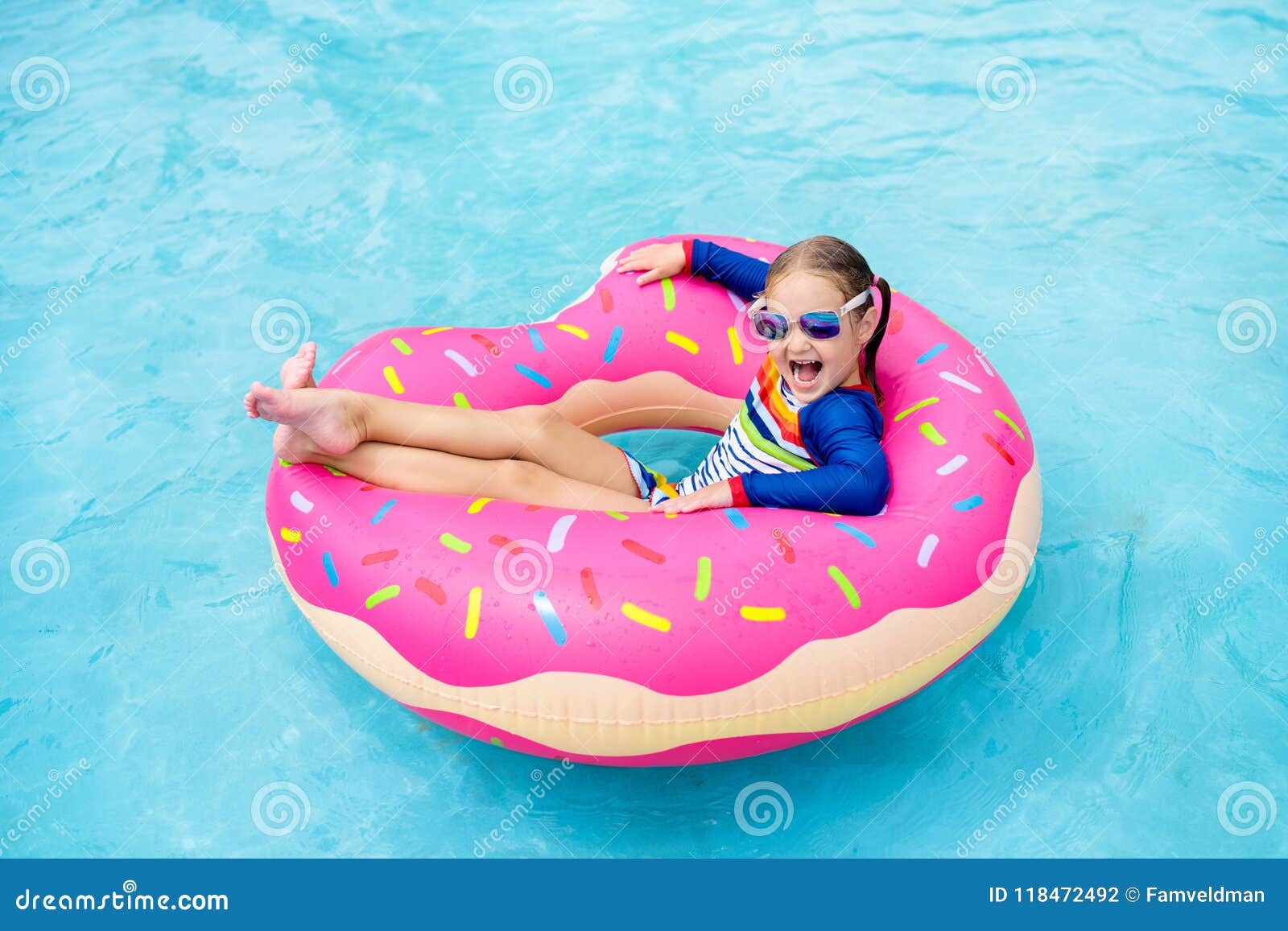 child in swimming pool on donut float