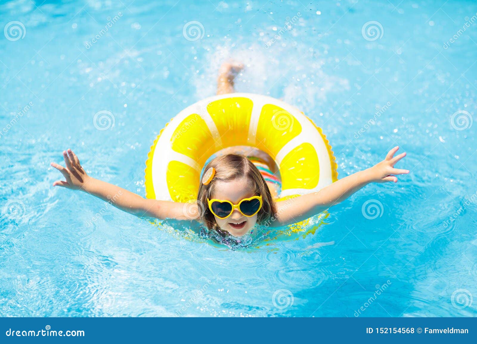 child in swimming pool on ring toy. kids swim