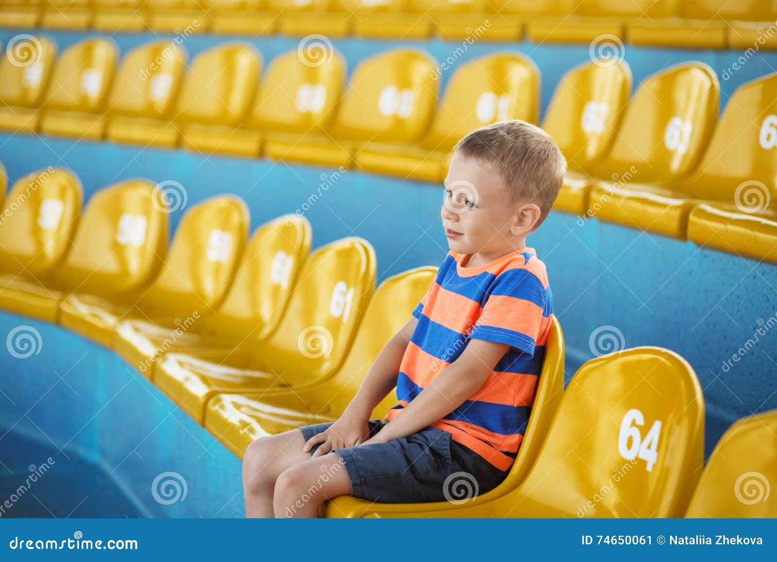 child take own seat in the stadium or dolphinarium and waiting p