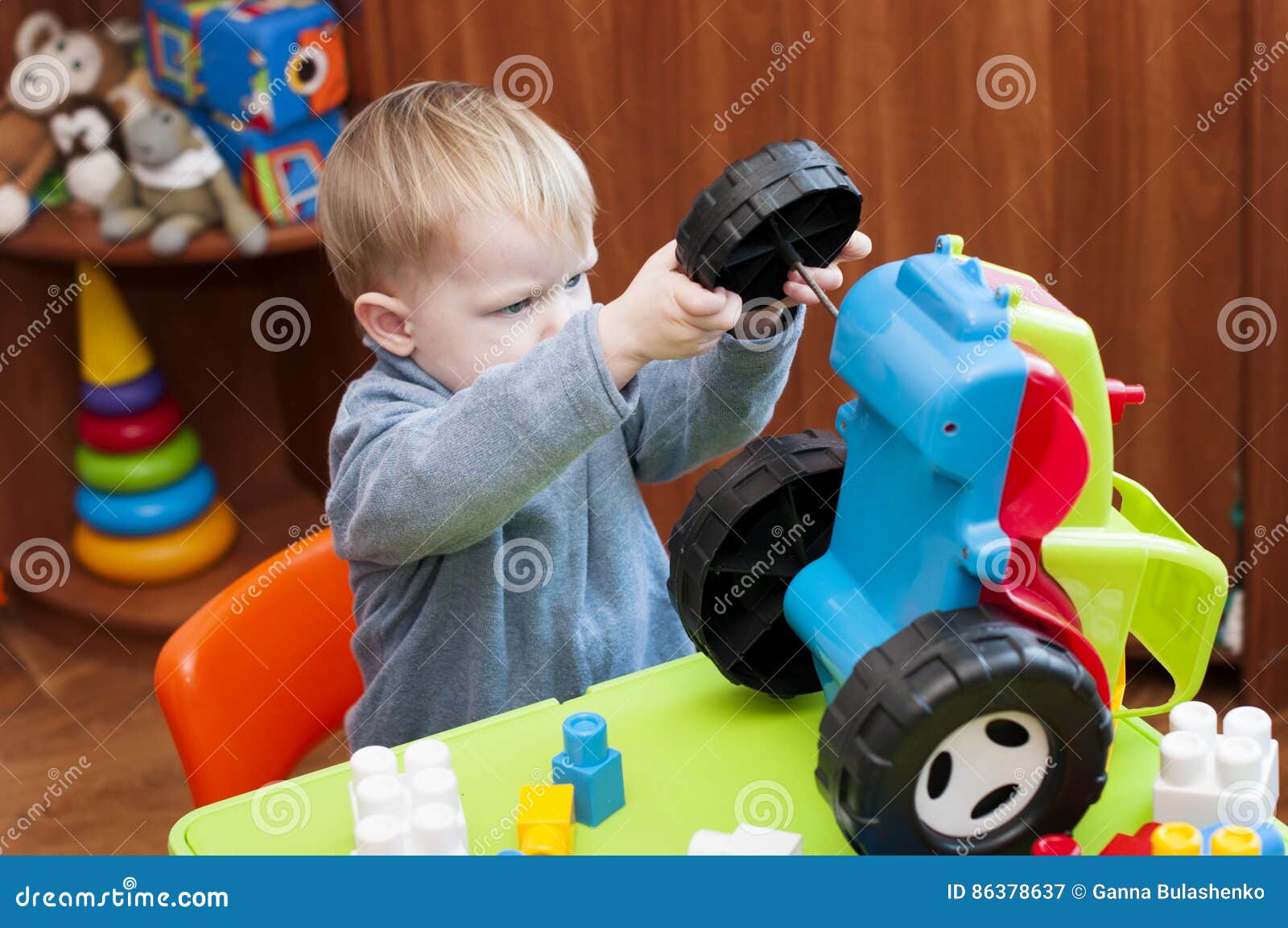 Child Tries To Fix A Broken Toy Tractor Stock Image Image of