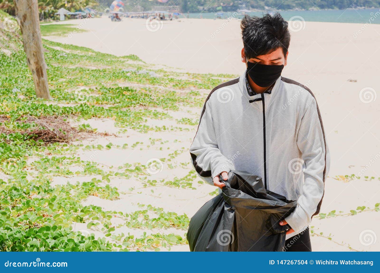 Child Volunteer Collecting Garbage On Beautiful Beach At Karon Beach
