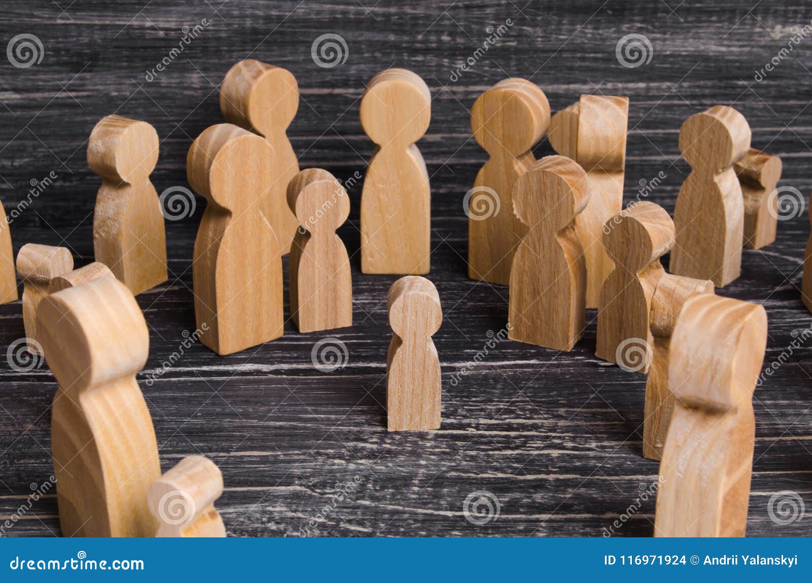 the child was lost in the crowd. a crowd of wooden figures of people surround a lost child. lost kid