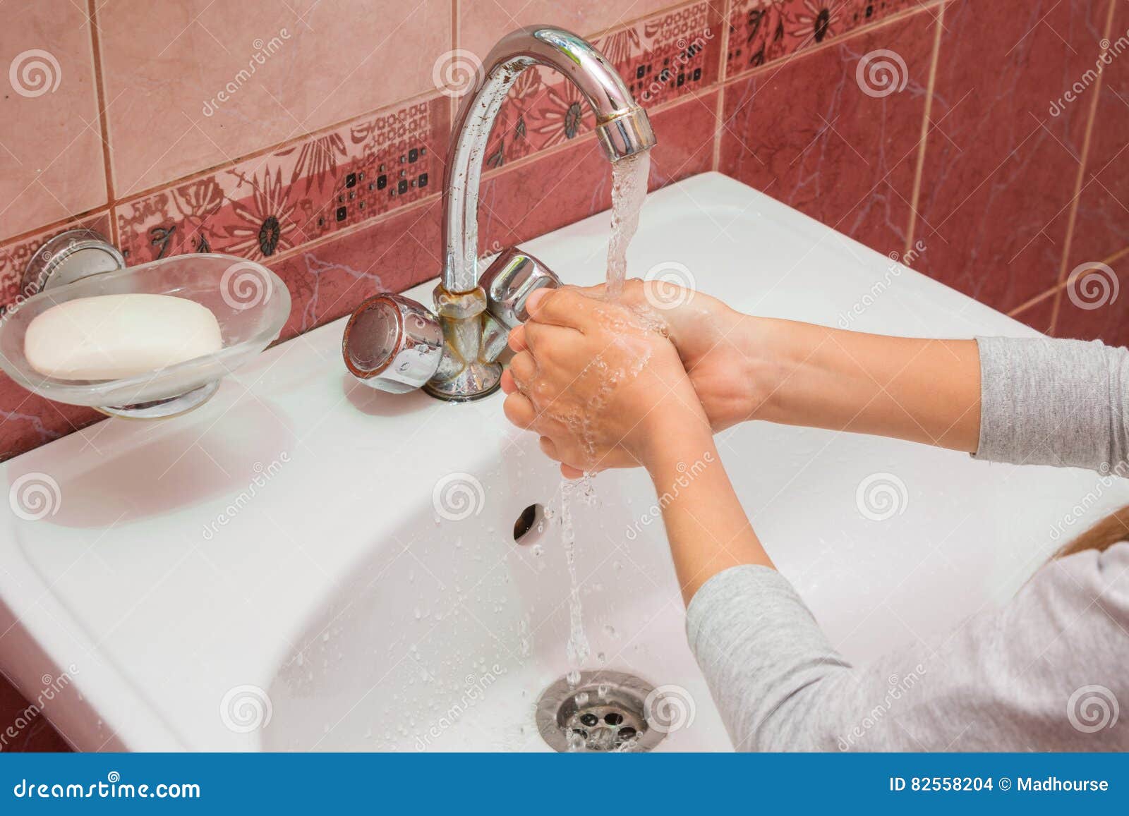 Child Washes His Hands Under Running Water in the Sink Stock Photo