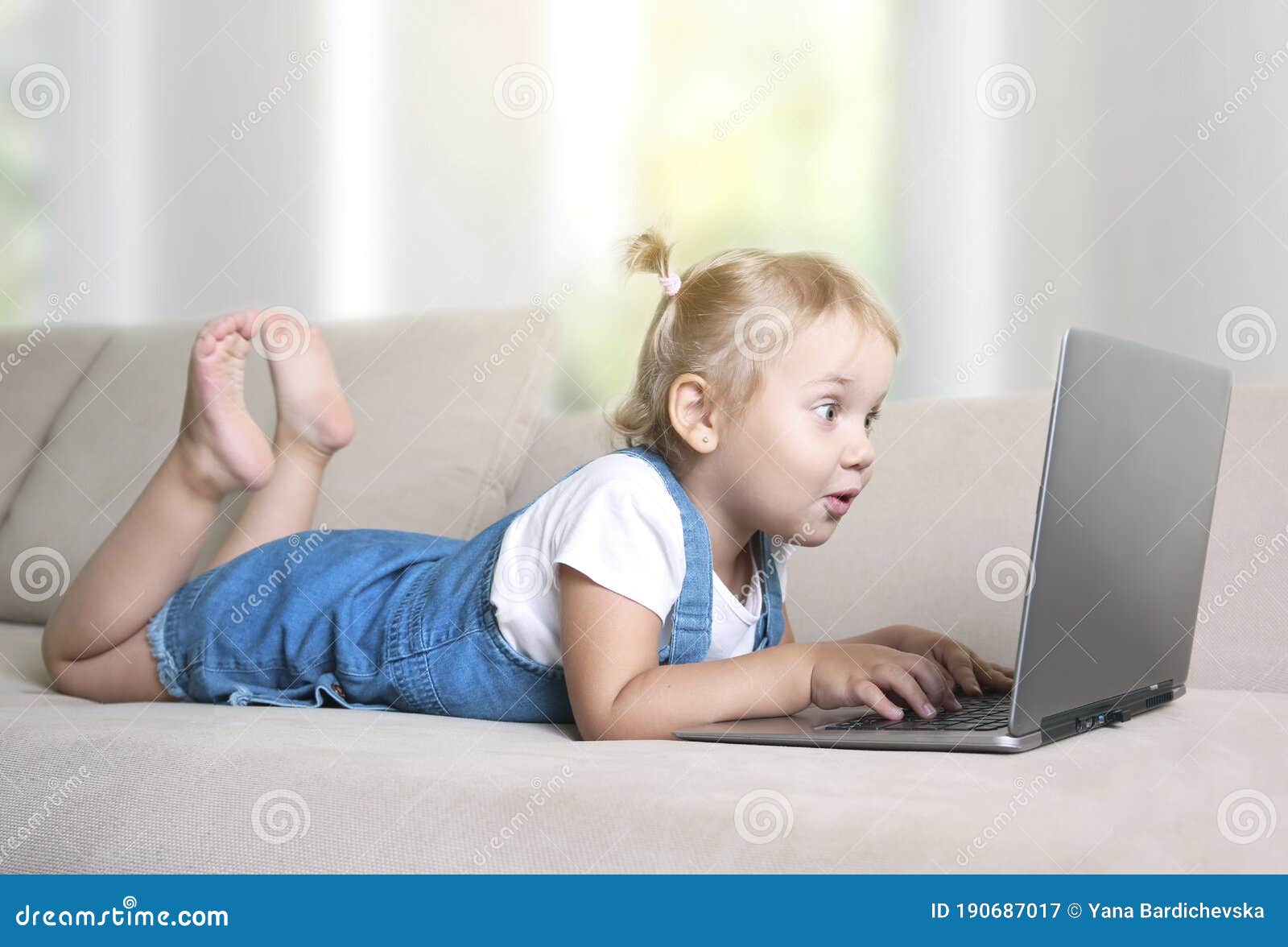 child watching laptop,using internet.kid with suprised face looks at notebook screen.addiction to internet,effect of technologies
