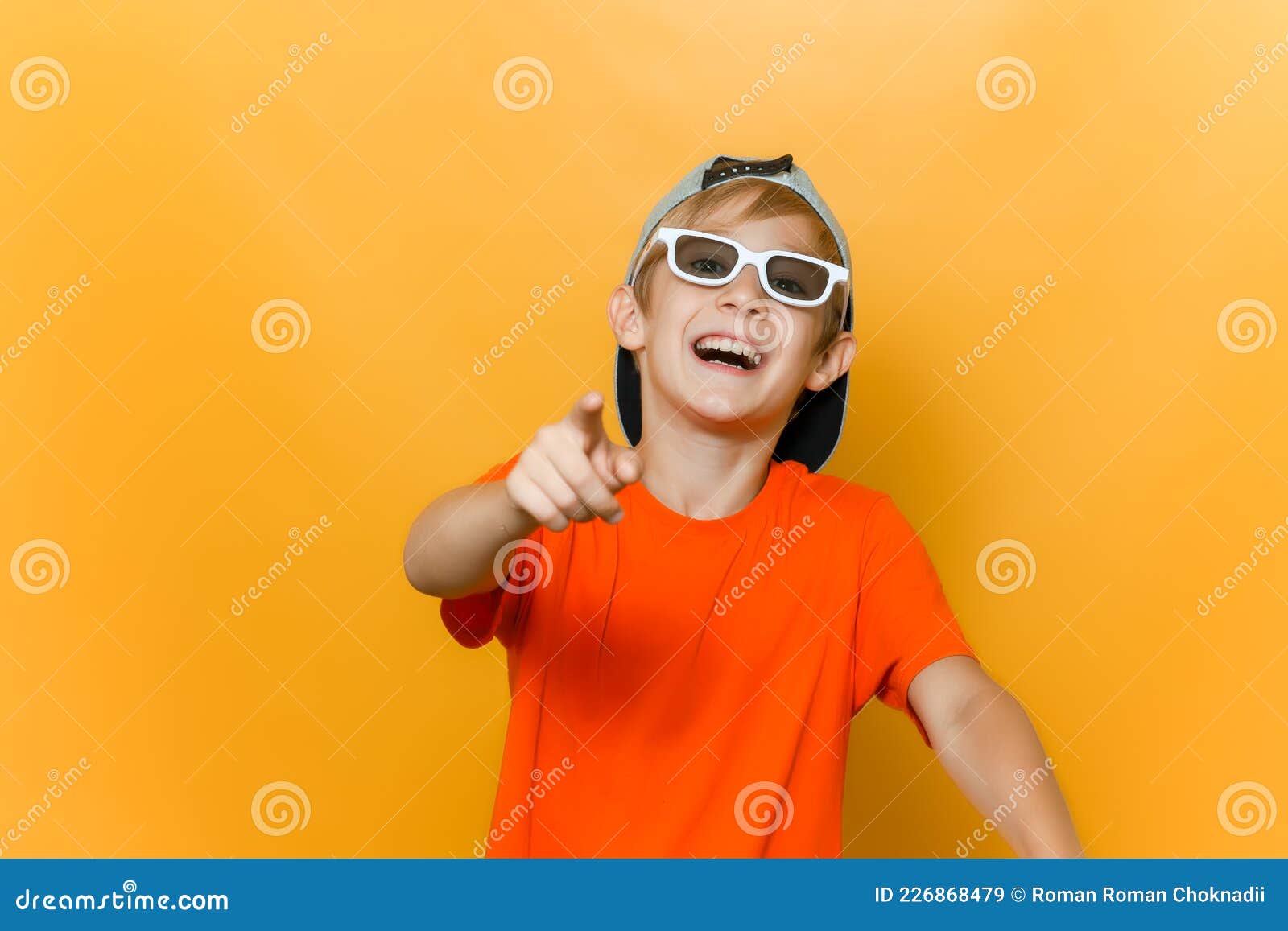 child wearing glasses for watching movies points his finger forward and mocks