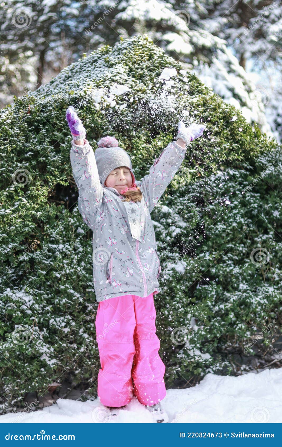 a child in a winter park throws snow over his head and blinks
