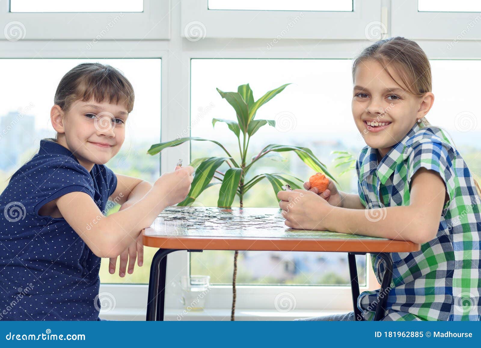 Children Assemble a Puzzle at Home and Happily Look into the Frame