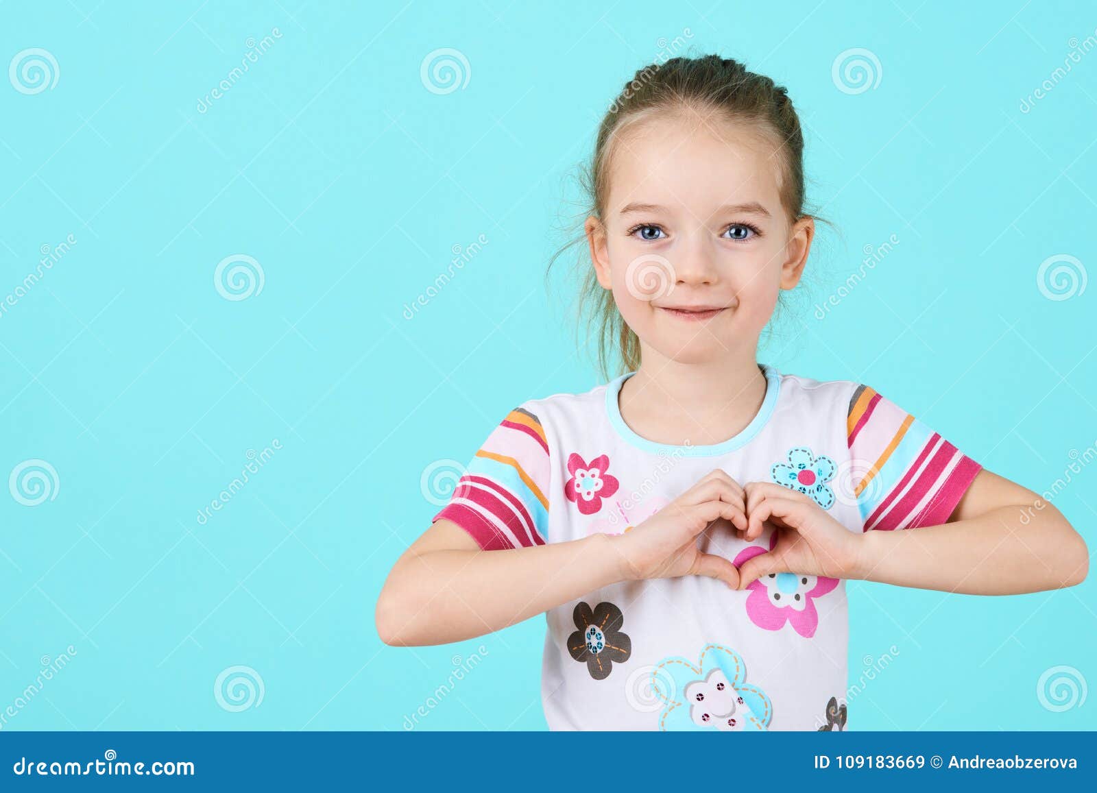 children, charity, healthcare, adoption concept. smiling little girl making heart- gesture.