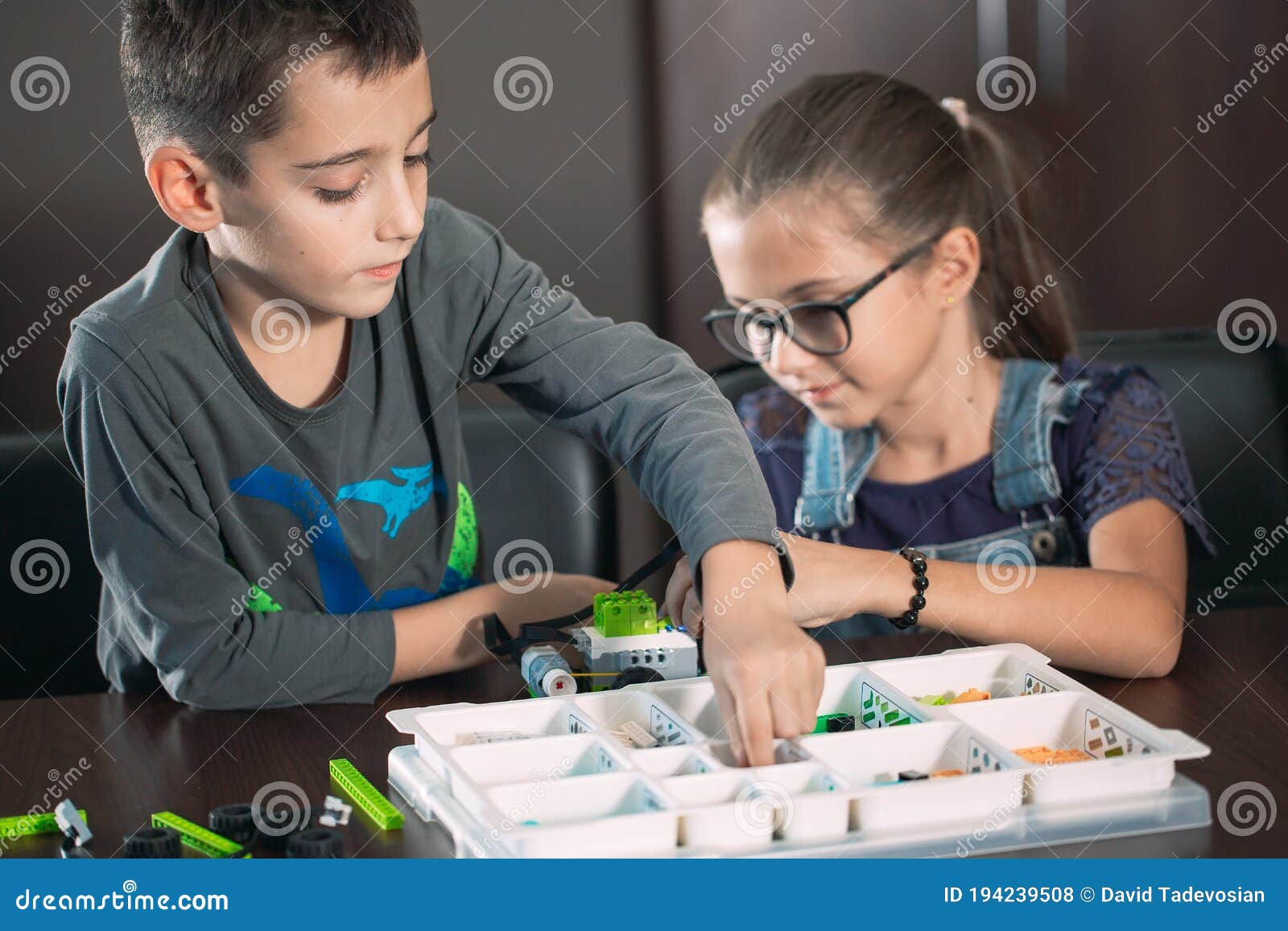 Children in the Classroom Collect Figure from the Designer. Stock Photo