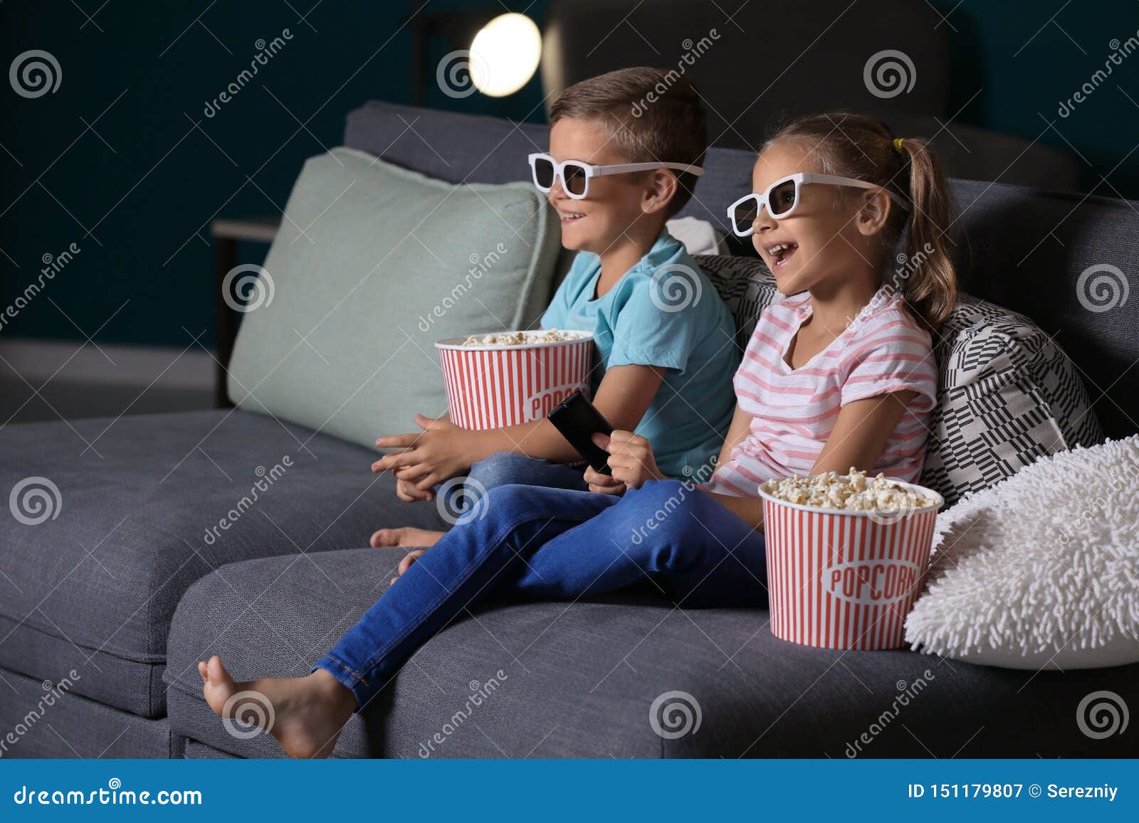Children Eating Popcorn while Watching TV in Evening Stock Image
