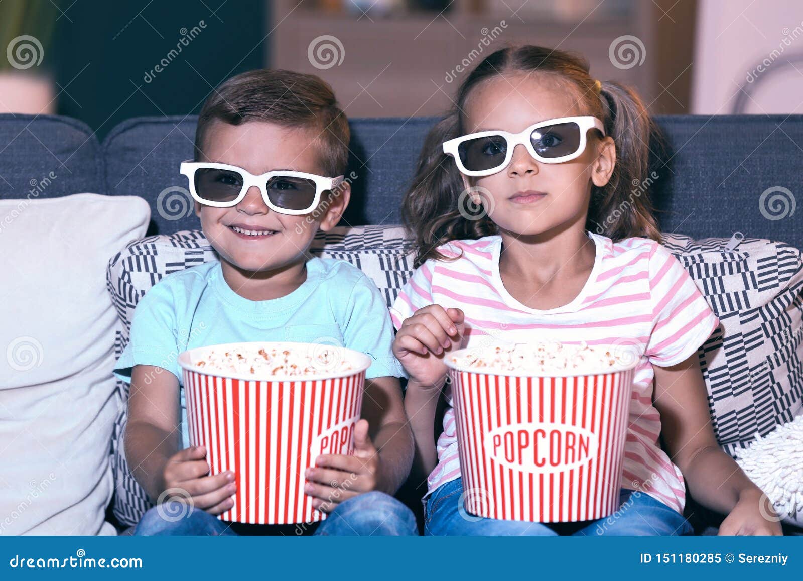 Children Eating Popcorn while Watching TV in Evening Stock Image