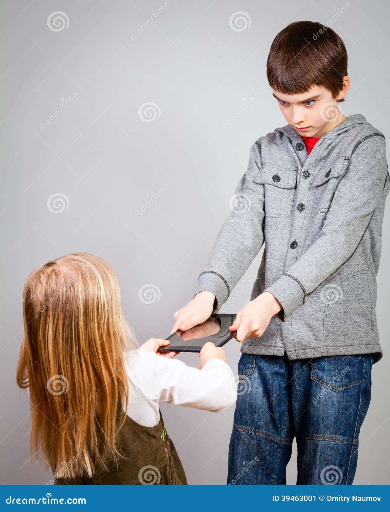 Children fight for tablet computer. Boy dont want to share a touch pad with little sister