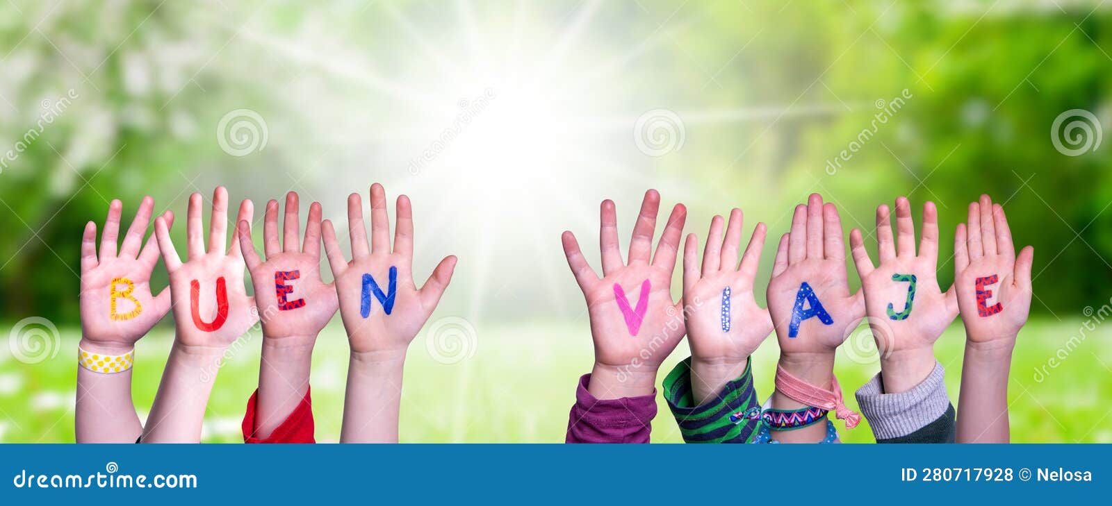 children hands building word buen viaje means good trip, grass meadow