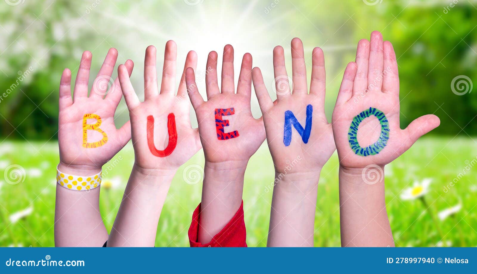 children hands building word bueno means good, grass meadow