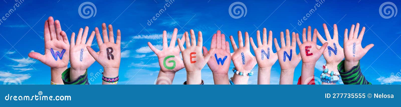children hands building word wir gewinnen means winning. blue sky