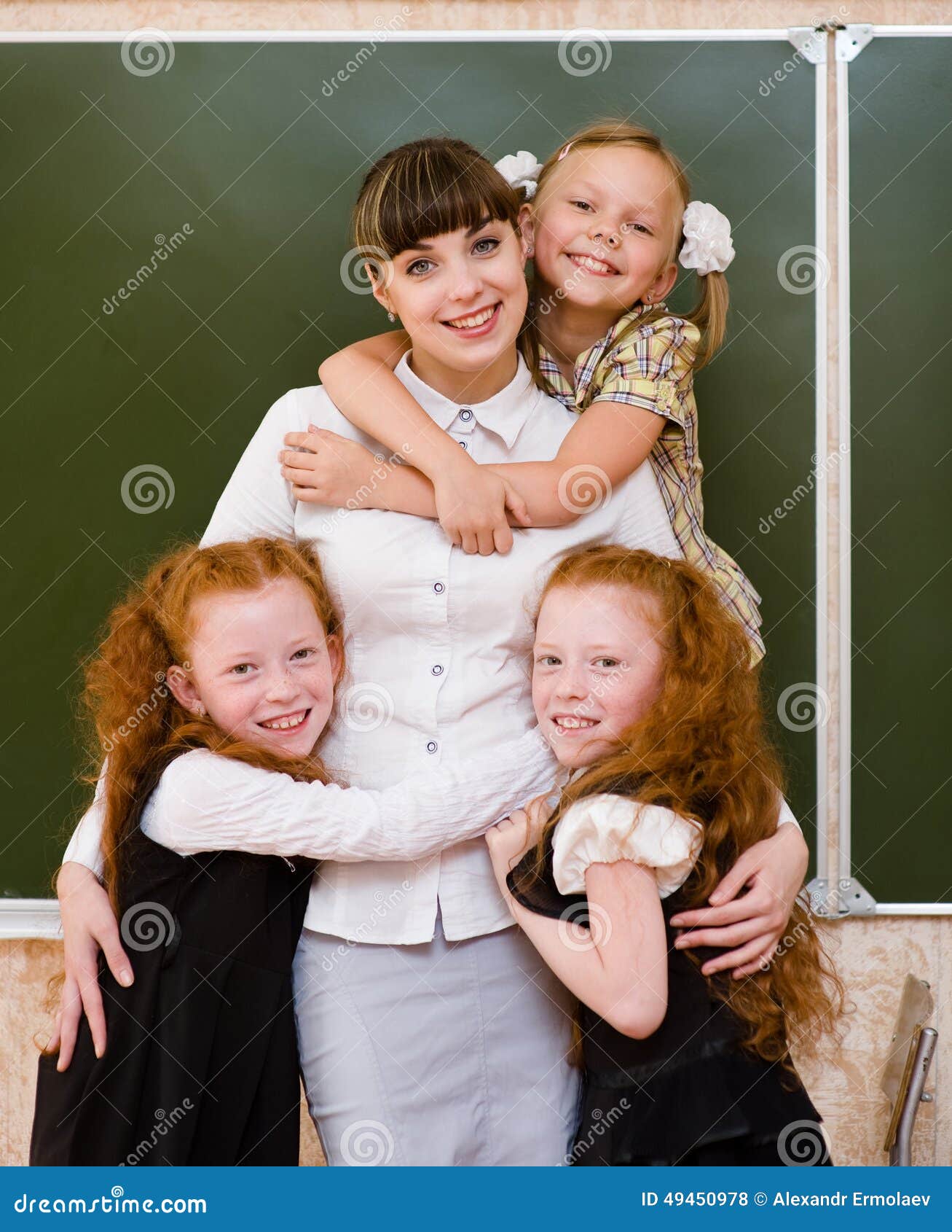 Children Hugging Their Teacher Stock Photo - Image of desk, indoor ...