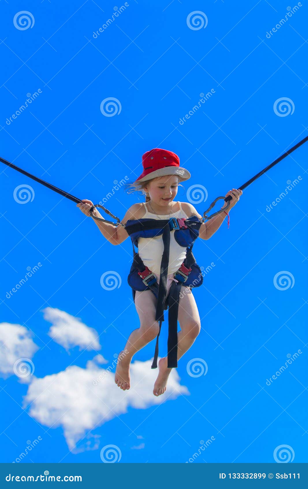 Children Jumping on a Trampoline with Rubber Ropes Against the B Stock
