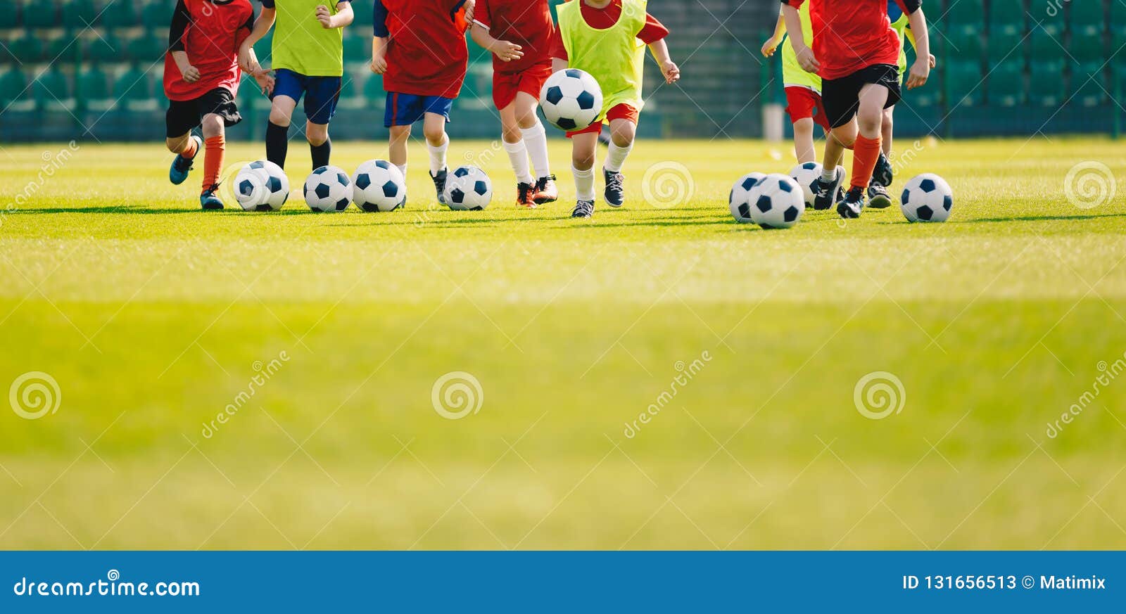children play soccer at grass sports field. football training for kids. children running and kicking soccer balls at soccer pitch