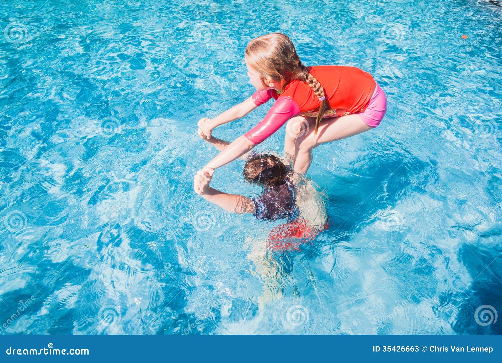 Brother and sister having fun in a swimming pool by Jakob 