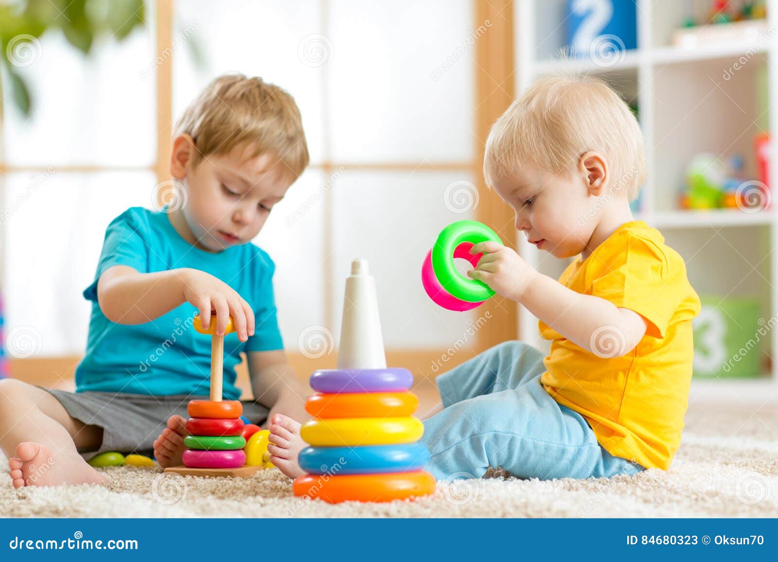 children playing together. toddler kid and baby play with blocks. educational toys for preschool kindergarten child