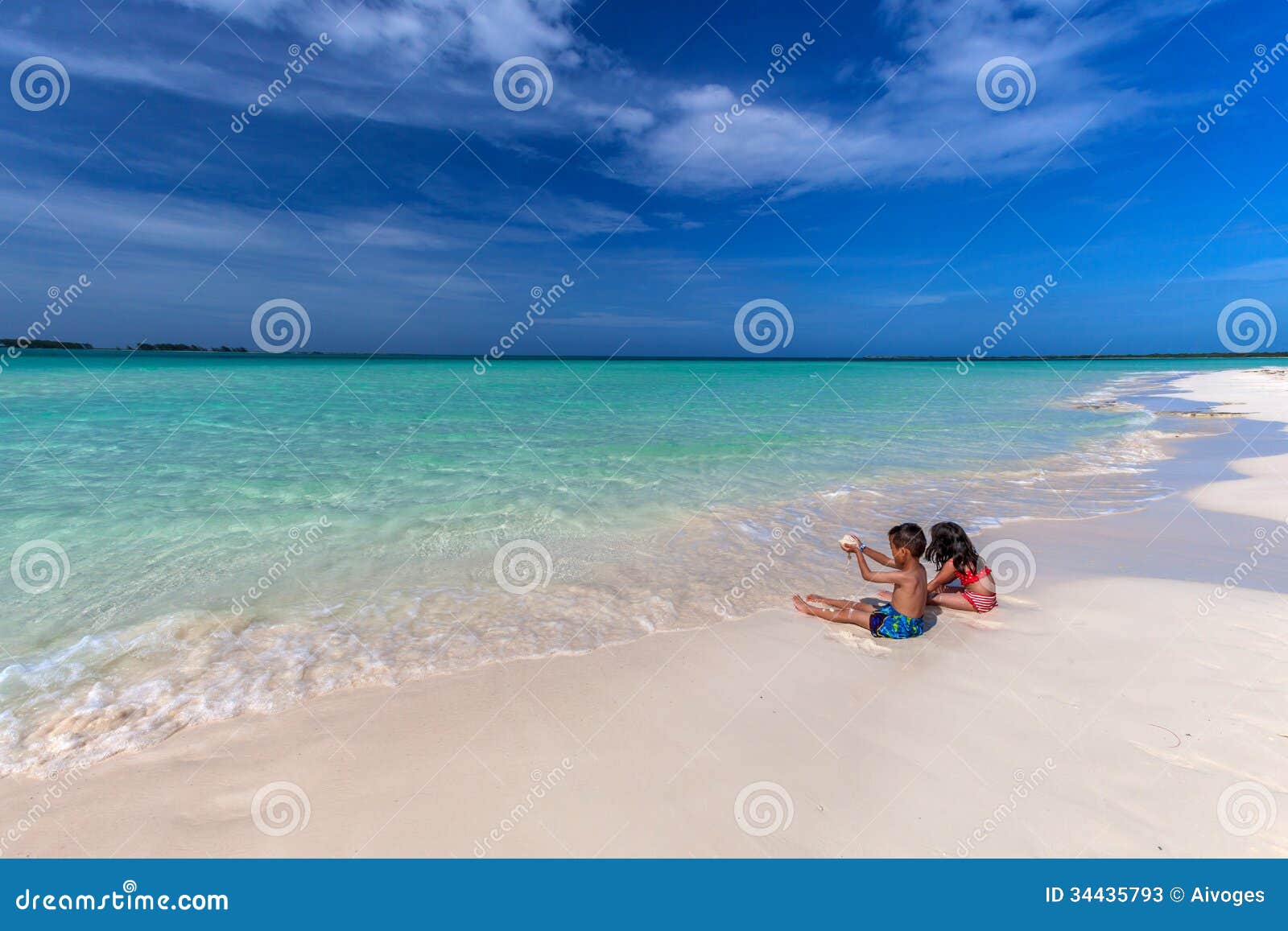 children playing on white sandy cuban beach in cayo coco