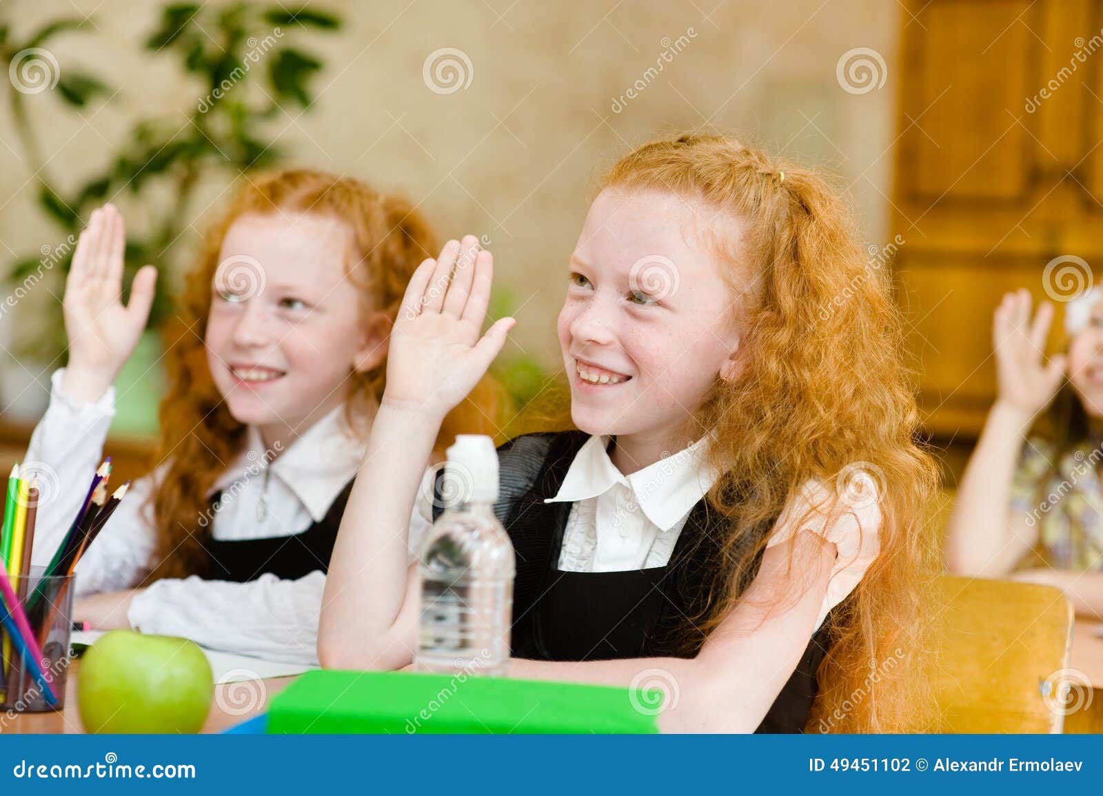 children raising hands knowing the answer to the question