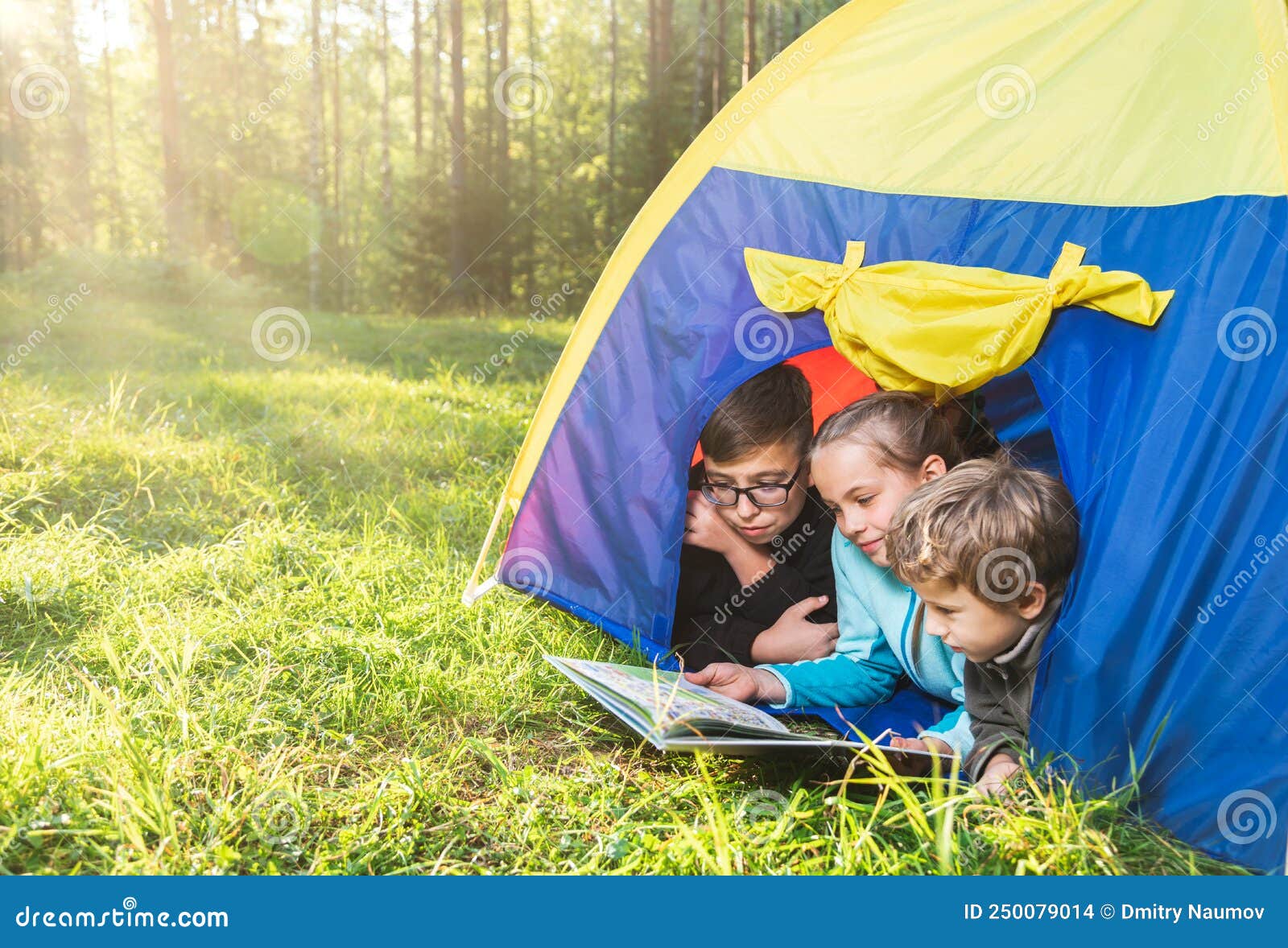 Sisters spending time in a tent on camping. Children using tablet playing games  online during summer vacation - a Royalty Free Stock Photo from Photocase