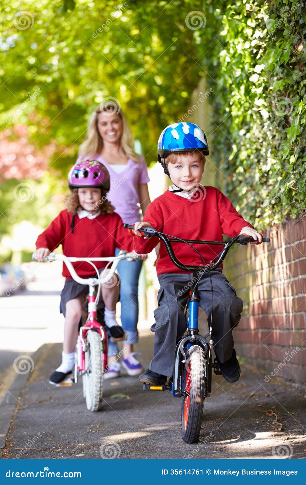 Children Riding Bikes On Their Way To School With Mother ...