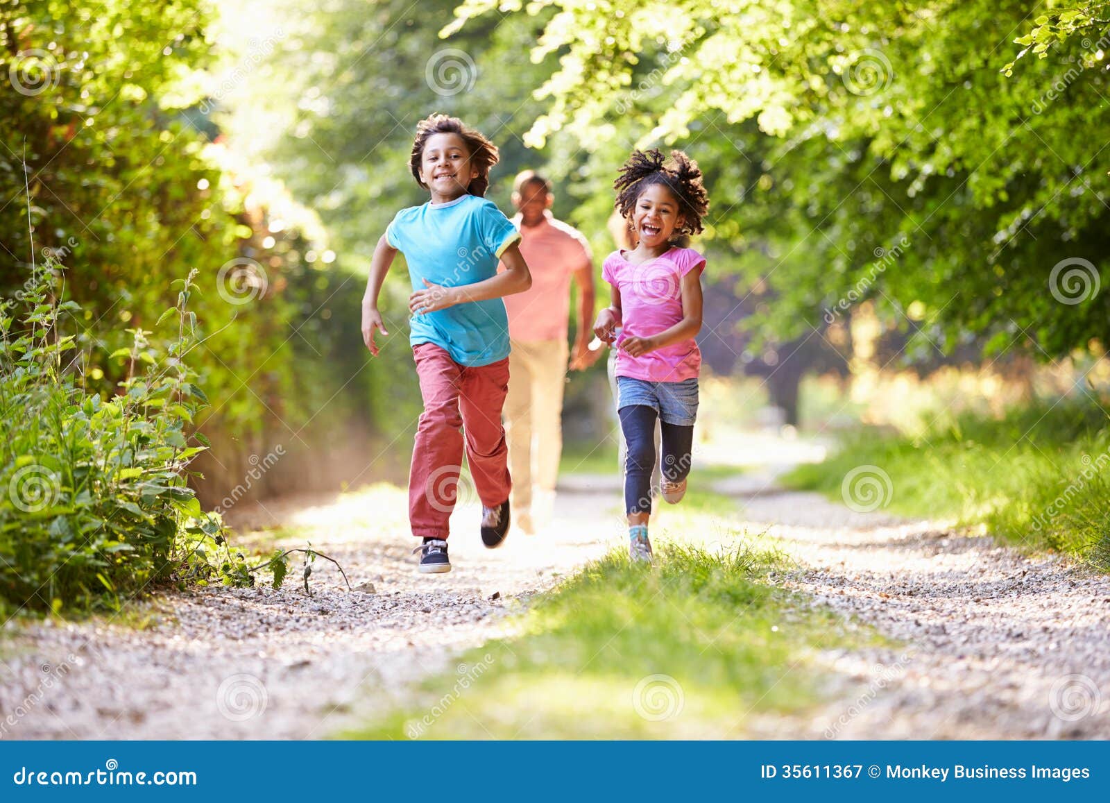 children running in countryside with father