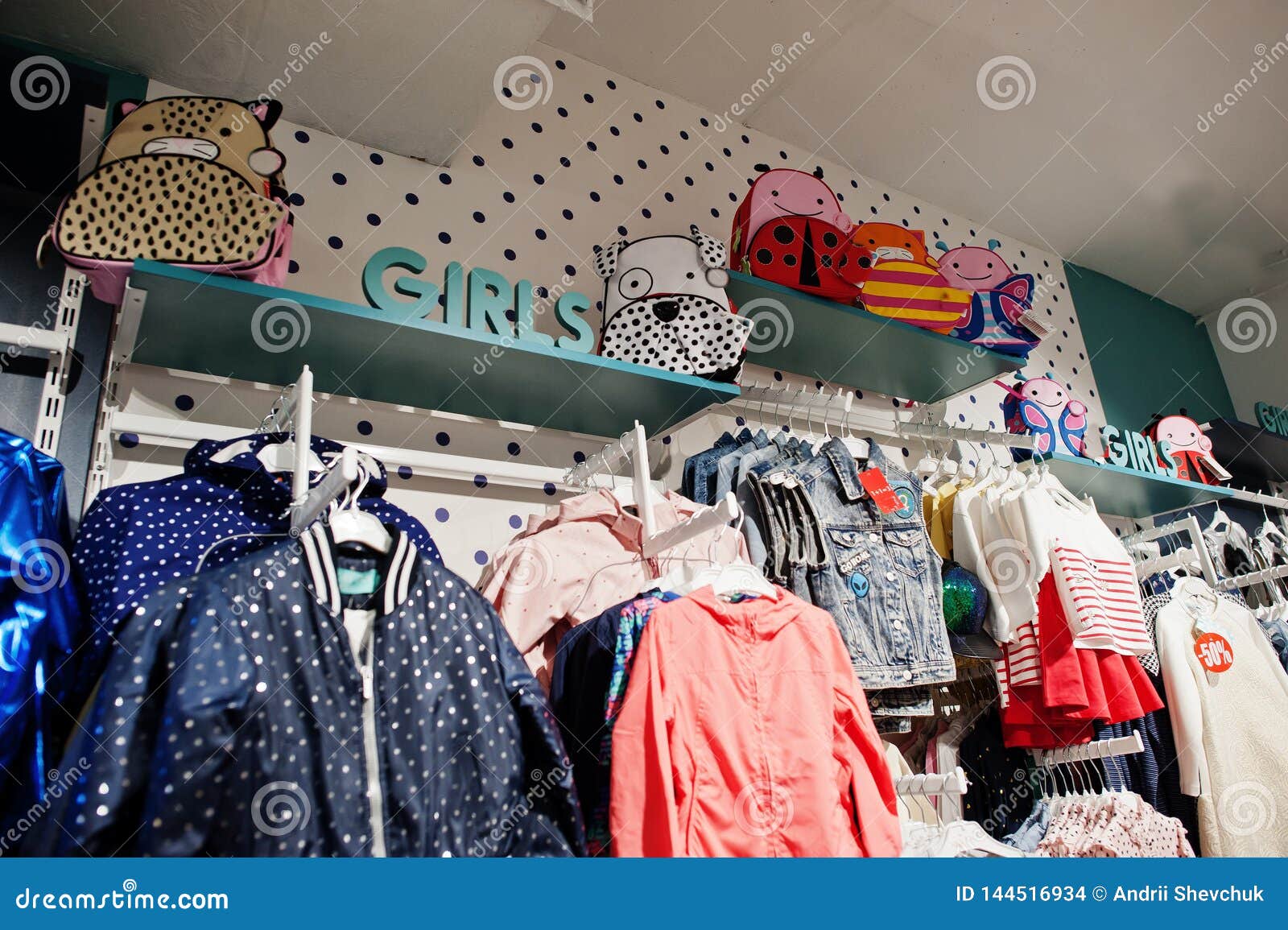 Children S Bright Clothes Hang On The Display In The Baby Clothing Store Girls Section Stock Photo Image Of Retail Purchase 144516934