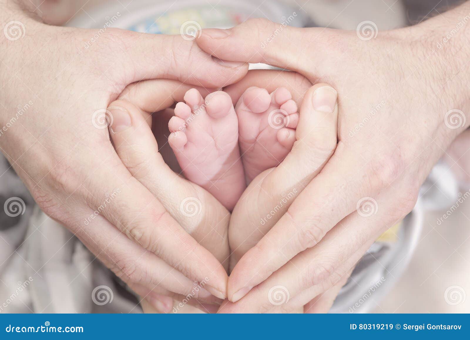 Children`s Feet in Heartshaped Hands of Mother and Father. Mother ...