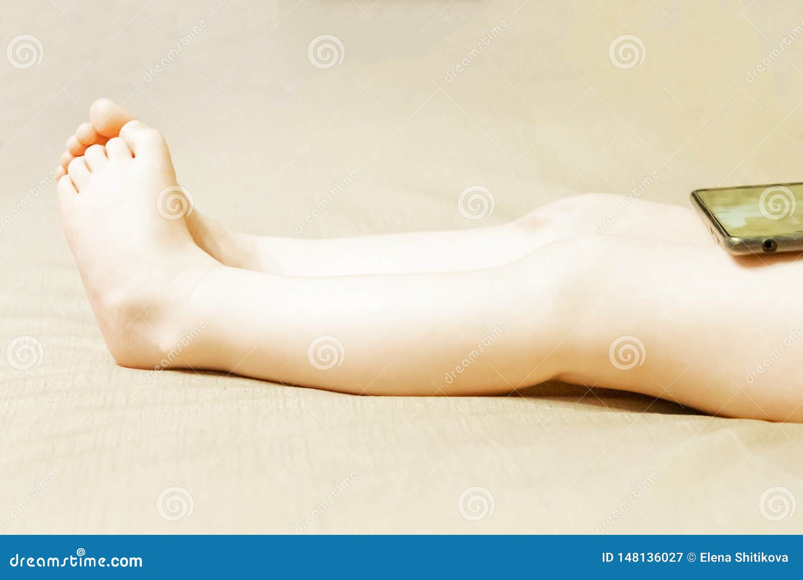 Children`s Feet. on the Legs of the Child is a Cell Phone Stock Image