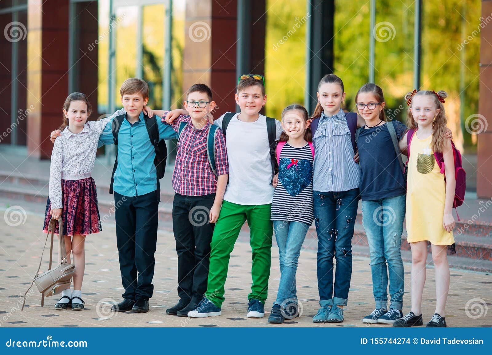 children`s friendship. schoolmate students stand in an embrace on the schoolyard.