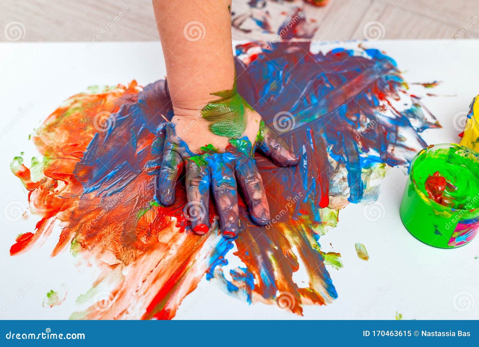 children`s hand in paints. finger paints. baby artwork . flat lay