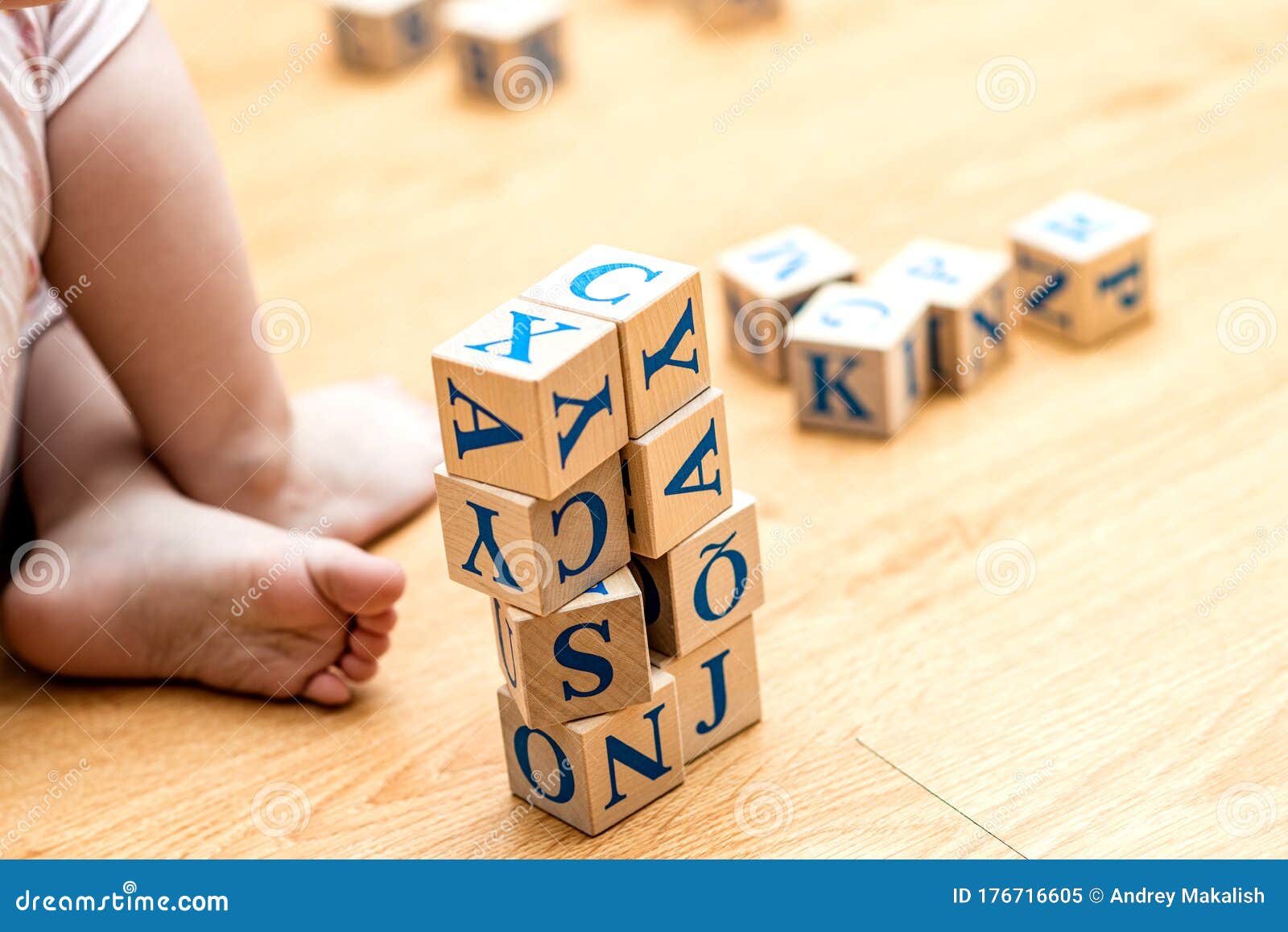 children`s hands and wooden cubes with alphabet