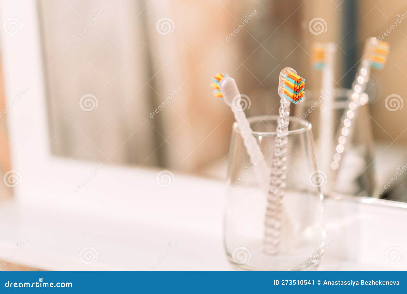 Children S Toothbrushes in Glass Cup in Front of Mirror Stock Image