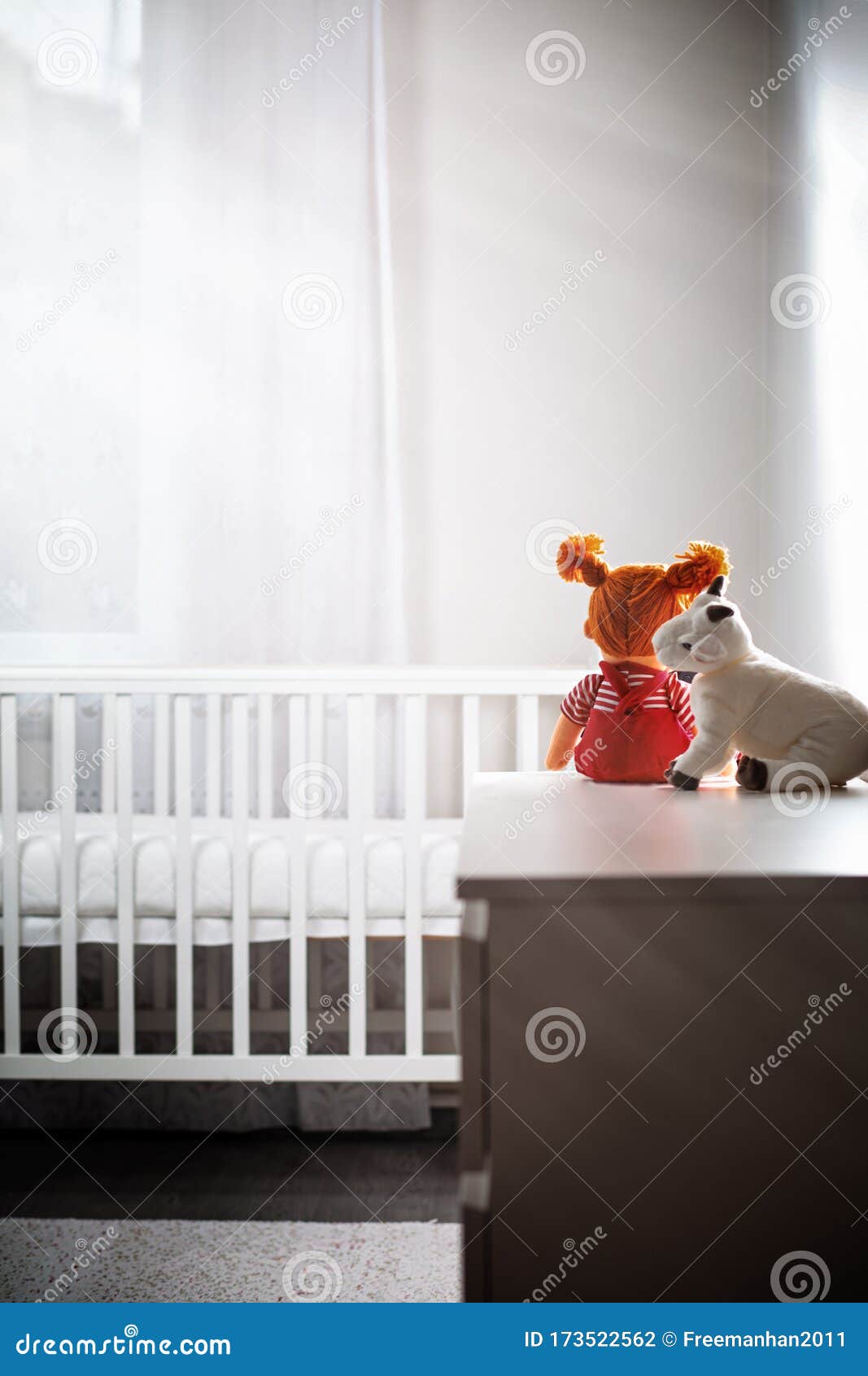 Children`s White Room with an Empty Cradle and Toys on the Dresser