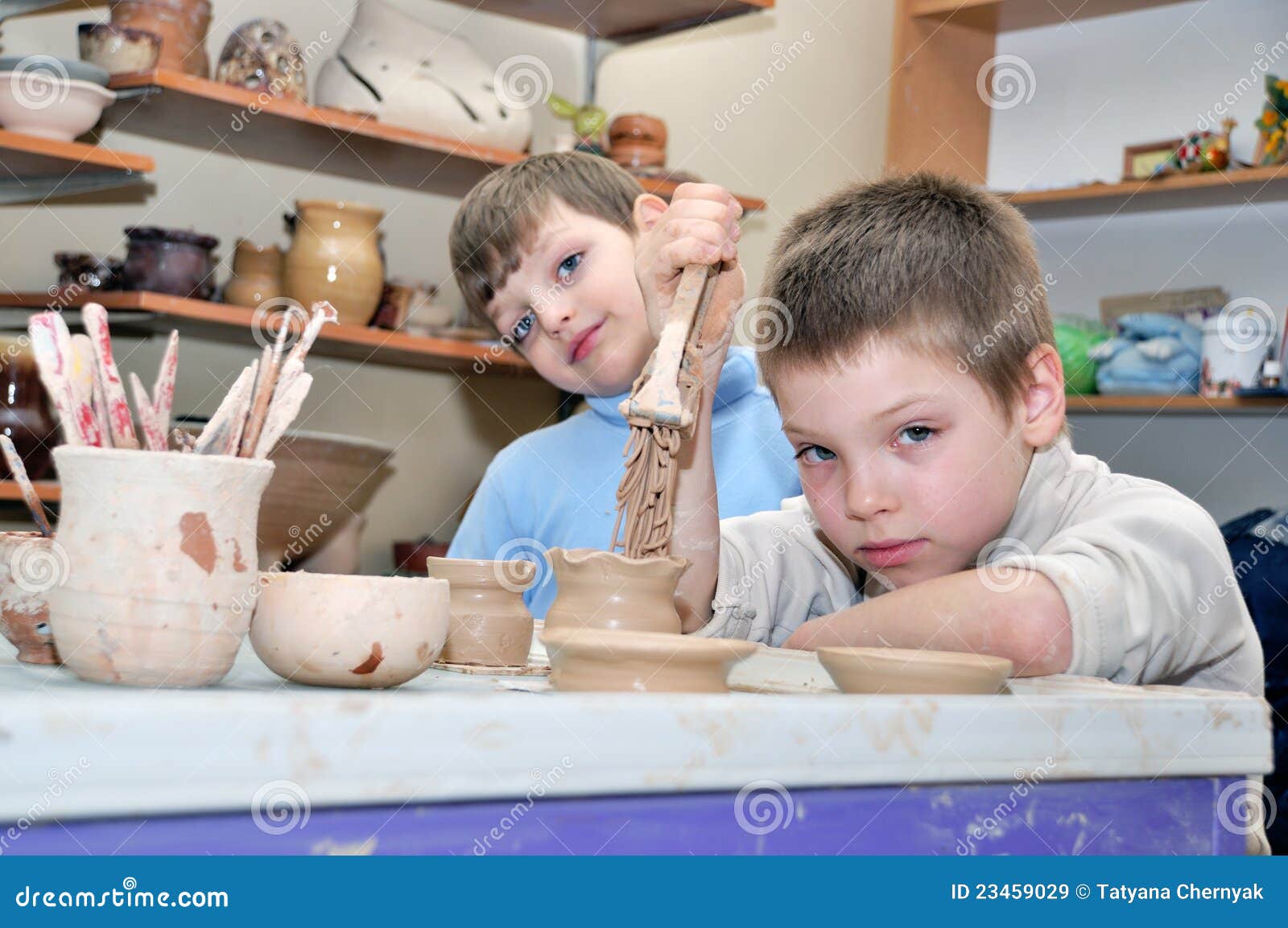 children shaping clay in pottery studio