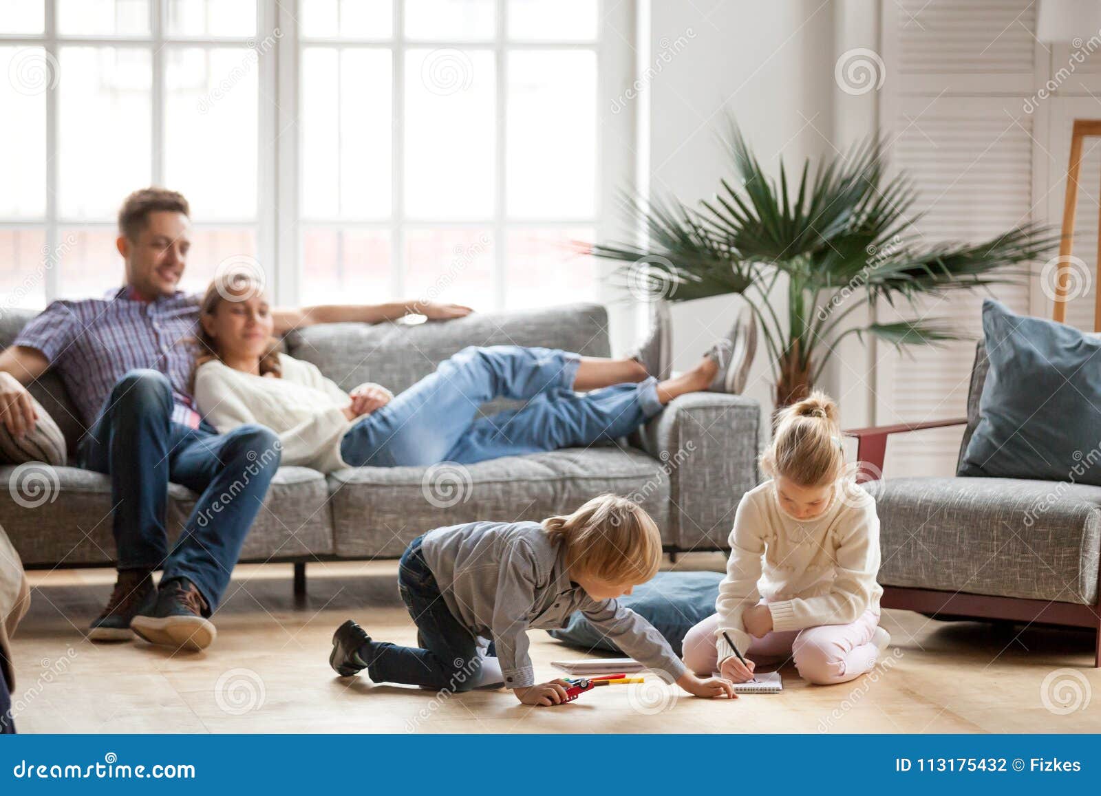 children siblings playing drawing together while parents relaxin