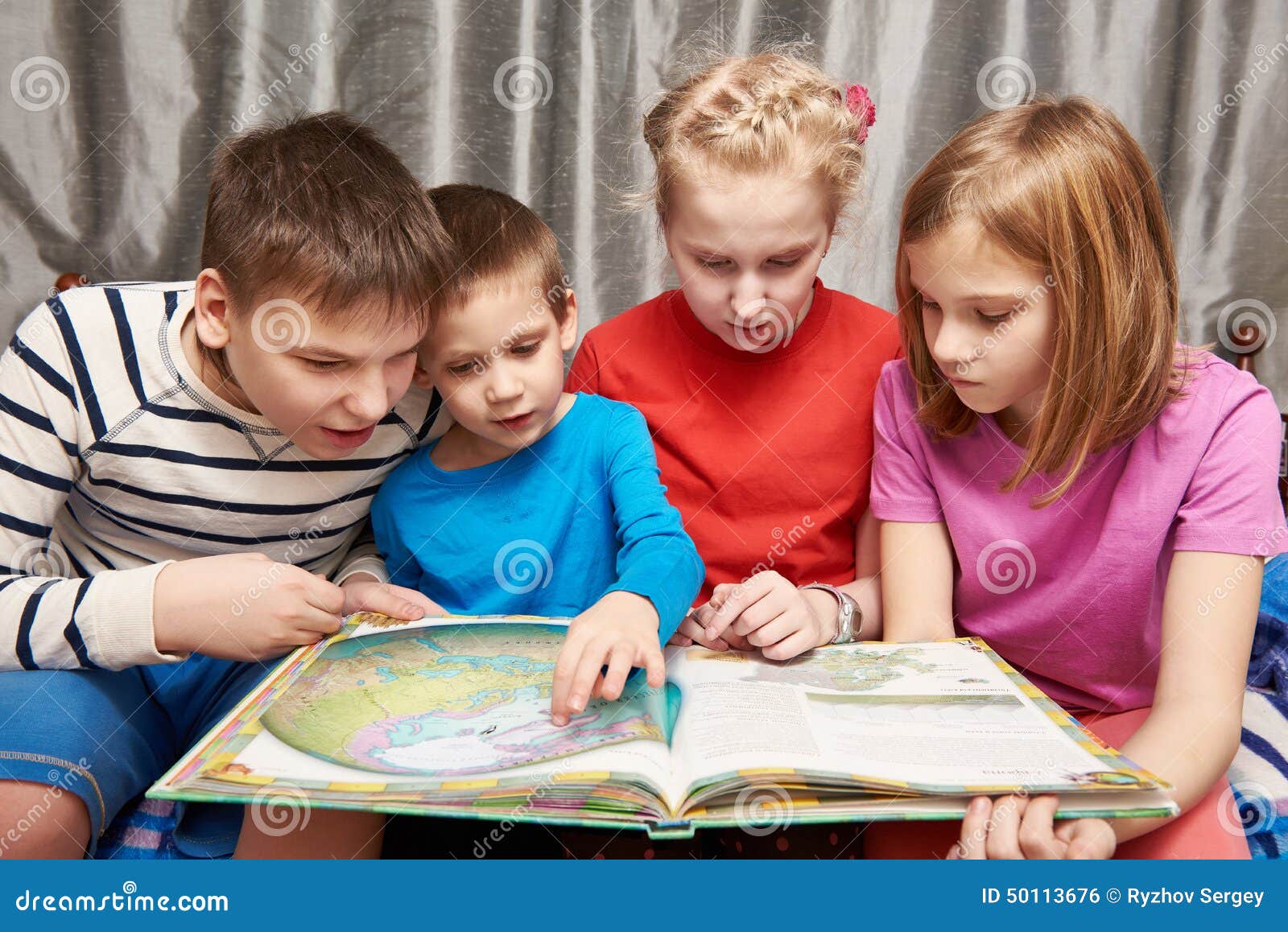 children sitting and reading geography book