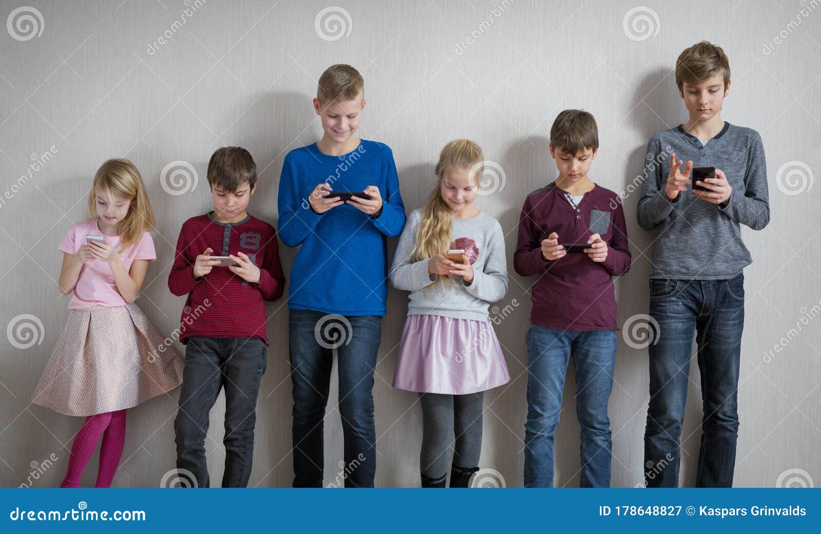 children standing and everyone using their own mobile phone