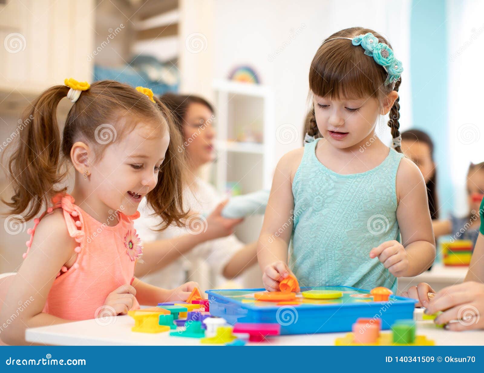 Childs Playing with Developmental Toys at Table in Kindergarten Stock