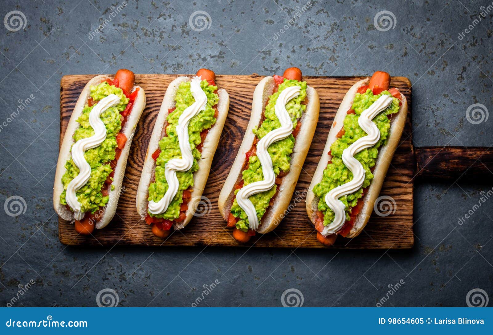 chilean completo italiano. hot dog sandwiches with tomato, avocado and mayonnaise on wooden board. top view.