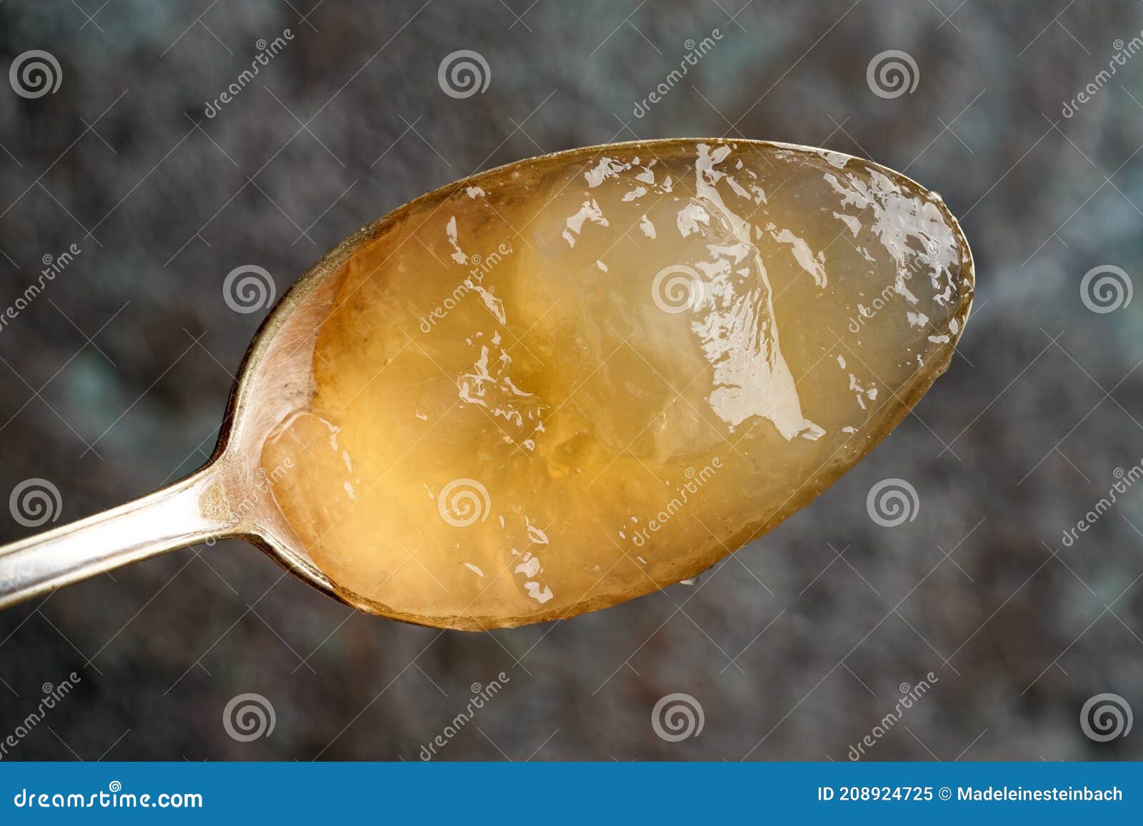 chilled congealed beef bone broth on a metal spoon  top view