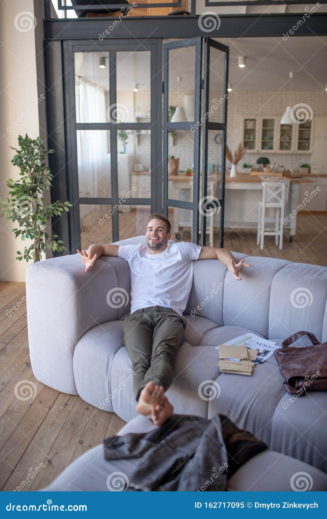 Businessman Chilling On Sofa After Coming Back Home From Work Stock