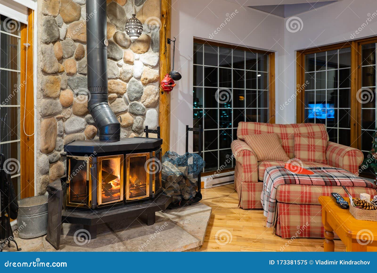 Acogedora habitación interior en una casa confortable con estufa de leña,  chimenea, puerta de cristal, cuerpo metálico y wic cercano