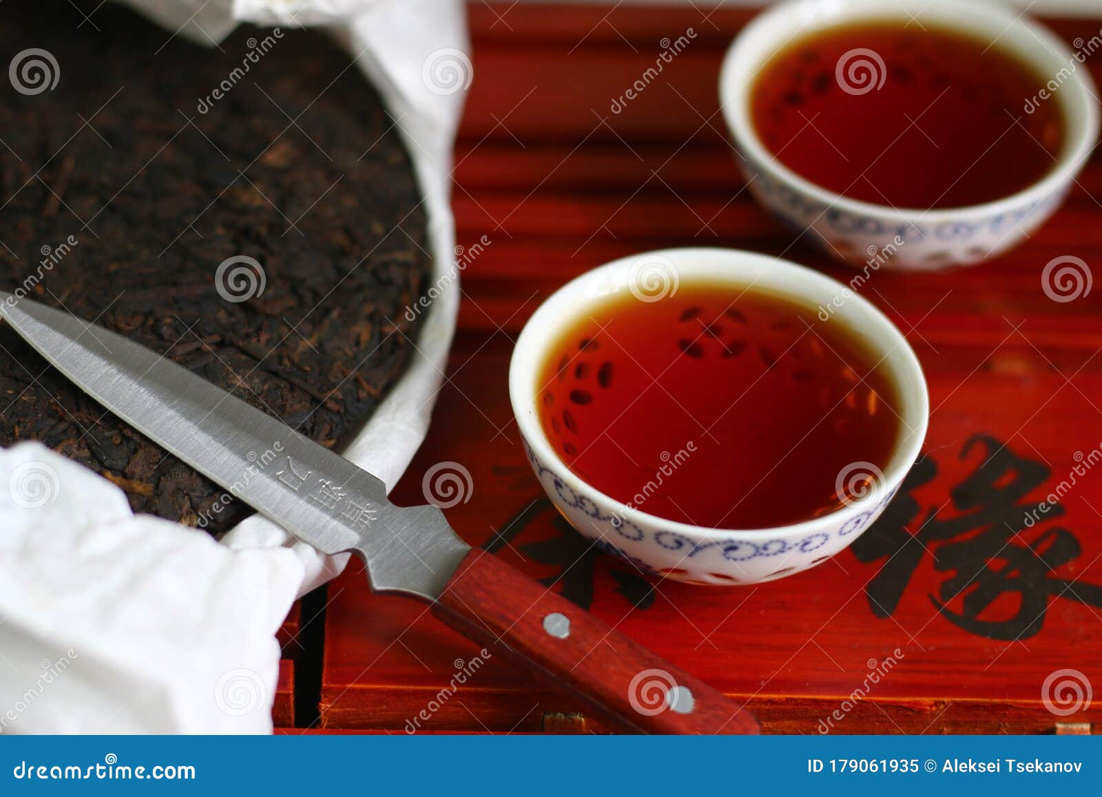 Bolo de chá pu-erh e faca para cerimônia de bebida.